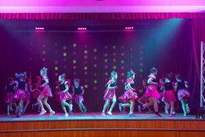 Kendi dejotājas rozā kostīmos uz skatuves