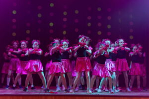 Kendi dejotājas rozā kostīmos uz skatuves