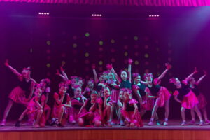 Kendi dejotājas rozā kostīmos uz skatuves